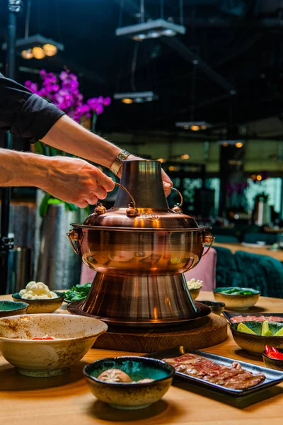 アジアの伝統的な鍋料理や器の材料をテーブルの上に並べ ストック画像
