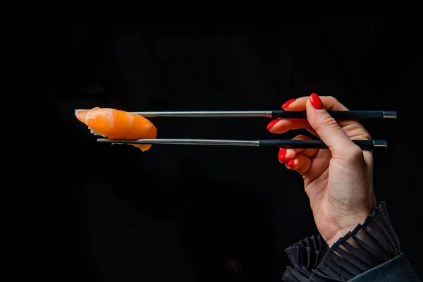 Corte Tiro Mulher Segurando Pauzinhos Comer Sushi Fundo Preto Fotografia De Stock