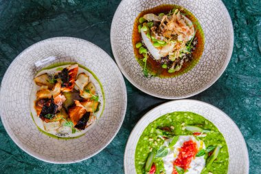 Koyu yüzeydeki tabaklarda servis edilen gurme çeşitliliğinin üst görünümü