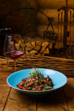 Kızarmış et, sebze, şifalı ot ve bir bardak kırmızı şarap ile nefis bir yemek.
