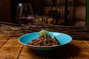 Kızarmış et, sebze, şifalı ot ve bir bardak kırmızı şarap ile nefis bir yemek.