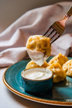 Lezzetli kızarmış hamur köftelerinin yakın çekim görüntüsü tabakta ekşi krema