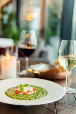 Sağlıklı yemek ve diyet konsepti. Bir tabak yeşil sebzeli yemek. Lokantada bir bardak şarap.