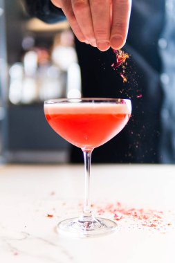 Restoranda kırmızı kokteyl yapan barmenin yakın çekimi. 