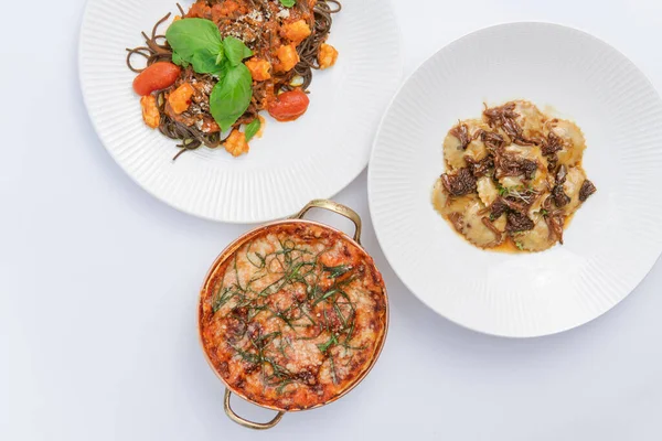 Beyaz yüzeydeki tabaklarda servis edilen gurme çeşitliliğinin üst görünümü