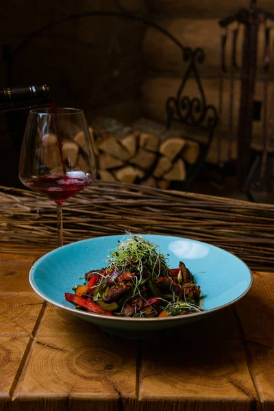 Kızarmış et, sebze, şifalı ot ve bir bardak kırmızı şarap ile nefis bir yemek.