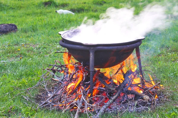 Ogromny miedziany kocioł ze smacznym grzanym winem gotowanym na otwartym ogniu — Zdjęcie stockowe