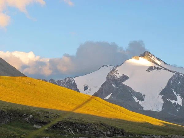 Bulutlardaki karlı dağ tepelerinin manzarası. Küresel ısınma ve buzulların erimesi kavramı.