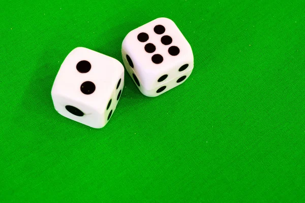 绿色布或桌布上的白色骰子 — 图库照片