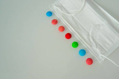 Tabletler ya da şekerler, beyaz ve renkli bir masada.  