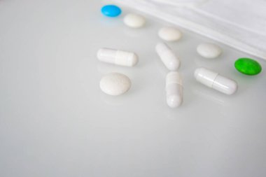 Tabletler ya da şekerler, beyaz ve renkli bir masada.  