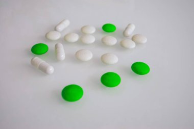 Tabletler ya da şekerler, beyaz ve renkli bir masada. 