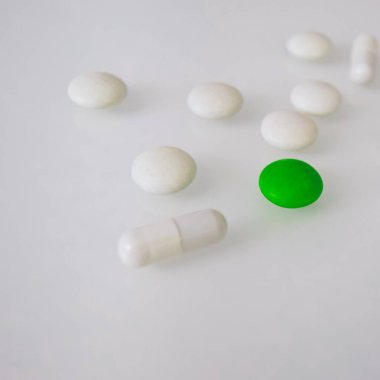 Tabletler ya da şekerler, beyaz ve renkli bir masada. 