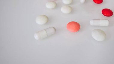 Tabletler ya da şekerler, beyaz ve renkli bir masada. 