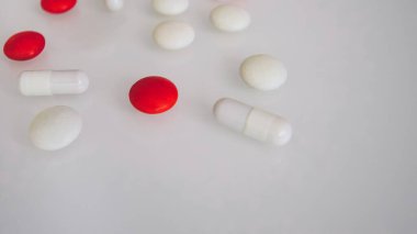 Tabletler ya da şekerler, beyaz ve renkli bir masada. 