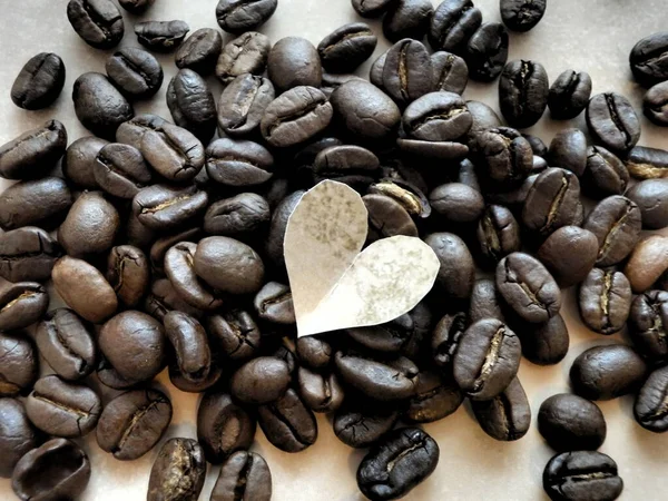 Paper heart on coffee beans.