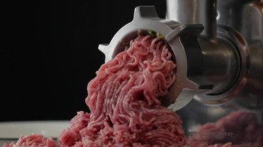 Et öğütme süreci, siyah arka planda kıyma.