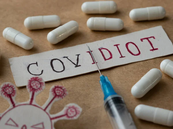 Covidiot Sticker Covidiot Handschriftlicher Text Coronavirus Spritze Und Tabletten Stockfoto