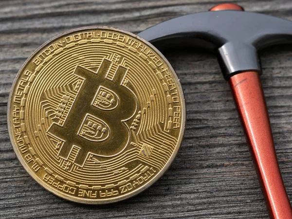 Bitcoin Und Spitzhacke Auf Hölzernem Hintergrund Physische Münze Btc lizenzfreie Stockfotos