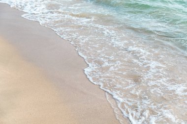 Kumlu sahilde okyanus dalgalarına yakın.