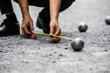 Petanque Alanındaki Petanque Ball 'un uzaklığını ölçen adam.