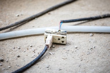 Eski elektrik prizi prizi ve kablo zeminde.