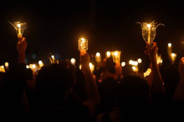 Dua etmek için elinde mum tutan insanlar