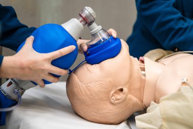 Manken hastaya ambu torbası tutan eller, ilk yardım eğitimi, kalp masajı tıbbi prosedürü.