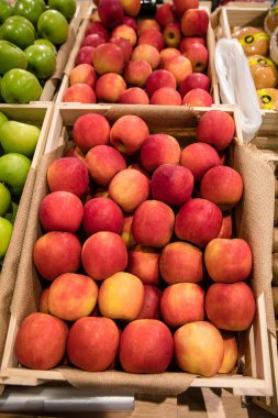 Yerel bir markette ya da süpermarkette satmak için tahta kutuda taze kırmızı elma yığını