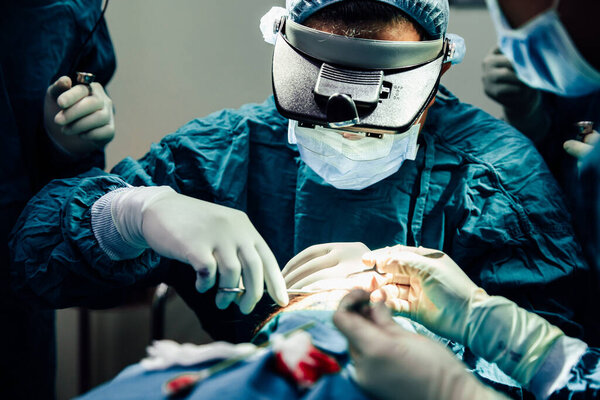 Close up doctor with surgical tools making surgery in the operating room, baldness treatment, hair transplant