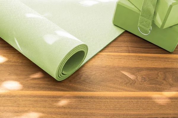 Yoga mat on a wooden background. Equipment for yoga.