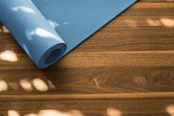 Yoga mat ahşap arka plan üzerinde. Yoga için donatım. 