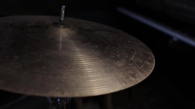 Yüksek şapkalı müzik aleti çalıyorum. Elinde bagetler olan müzisyen bateristin elleri arka planda çarpma ziline vuruyor, yakın plan görüntüsü. Davul zili titreşimi