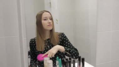 Çekici kadın sabah uyandığında güne başlamak için hazırlanıyor. Makyajını fırçayla yapıyor, bronzlaştırıcı sürüyor.