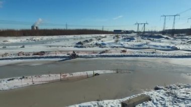 Bir motosikletçi kış pistinde gösteri yapar.