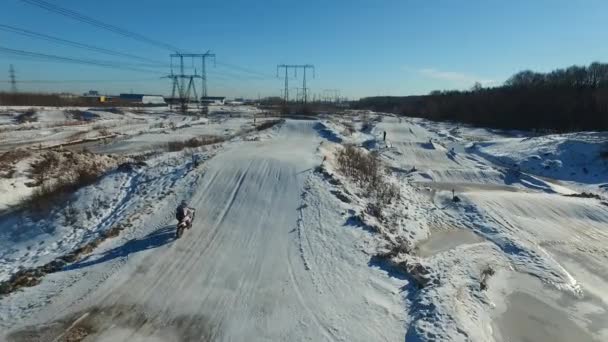 En motorcyklist utför stunts på en vinterbana — Stockvideo