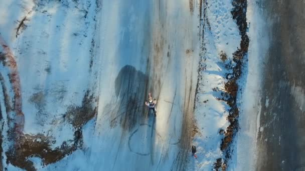 Egy motoros mutatványokat hajt végre a téli pályán — Stock videók