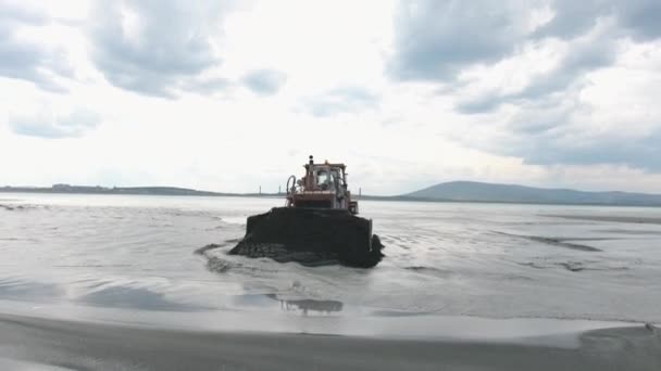 Žlutý buldozer vyčistí nábřeží, vzdušný člun — Stock video