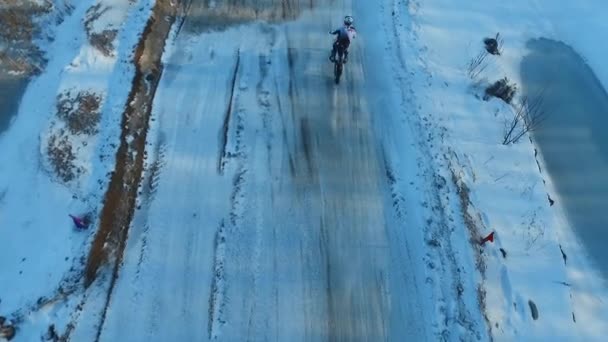 Motocyklista provádí kaskadérské kousky na zimní trati — Stock video