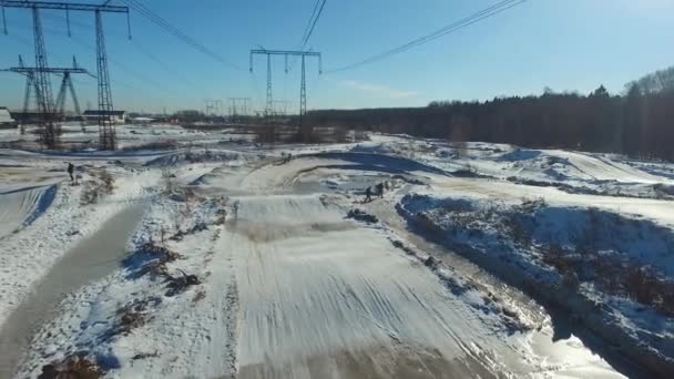 Egy motoros mutatványokat hajt végre a téli pályán — Stock videók