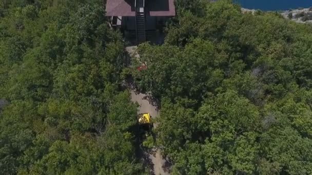 Ein junges Unternehmen auf den gelben und roten Autos, kam zum Sommerhaus Yoga, am Rande des Berges in der Nähe des Meeres — Stockvideo