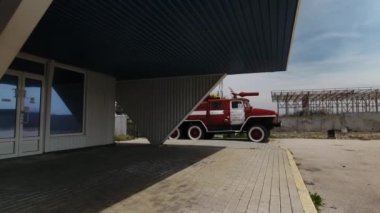 Eski itfaiye aracı, terk edilmiş bir binanın yanında..
