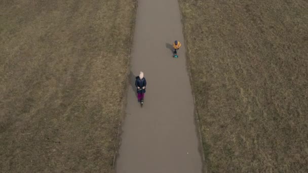 27 mars 2020 Ryssland, två barn rida skotrar på asfalterad väg tom — Stockvideo