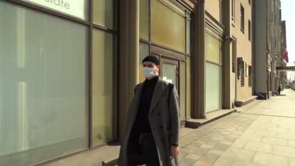 Moscú, Rusia-Marzo 2020. hombre con una máscara protectora de covid-19 caminando solo por el centro de la ciudad, nadie alrededor . — Vídeo de stock