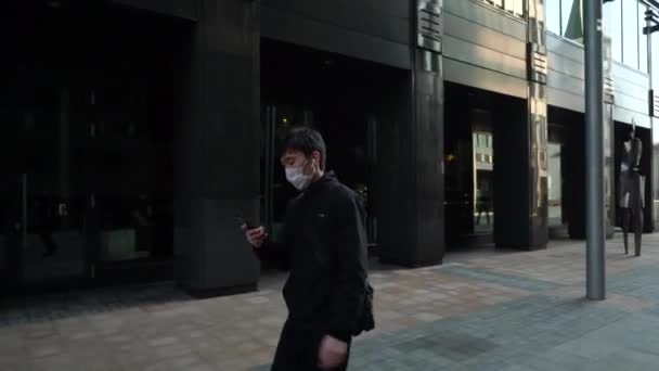 Moskva, Ryssland-mars 2020. man i en skyddande mask från covid-19 promenader ensam genom centrum, ingen runt. — Stockvideo