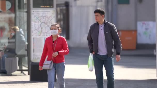 Moscou, Rússia-março 2020. menina em uma máscara médica de covid-19, seu companheiro ignora a proteção, passear pelo centro da cidade — Vídeo de Stock