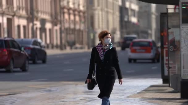 Moscow,Russia-March 2020. girl in a protective mask from the corona virus walking down the street one — Stock Video