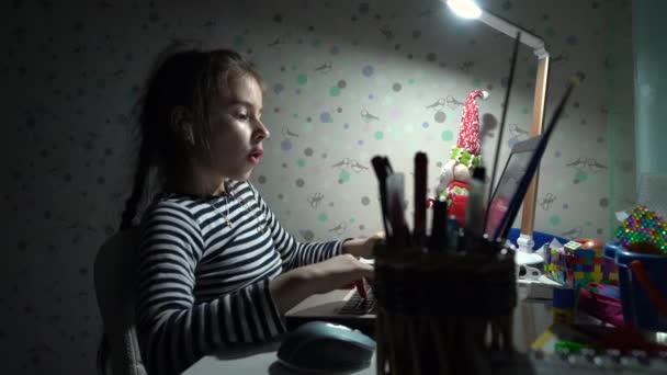 Jong meisje schoolmeisje doet lessen thuis op de laptop vanwege de quarantaine coronavirus — Stockvideo