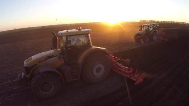 Algunos tractores pueden arar un campo al amanecer — Vídeos de Stock