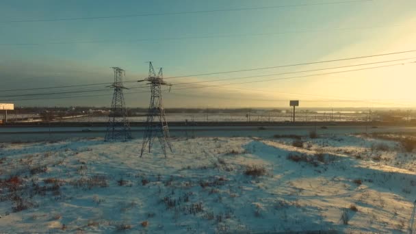 Γραμμές παραγωγής ηλεκτρικού ρεύματος και κατά μήκος της εθνικής οδού την αυγή, θέα από ψηλά — Αρχείο Βίντεο